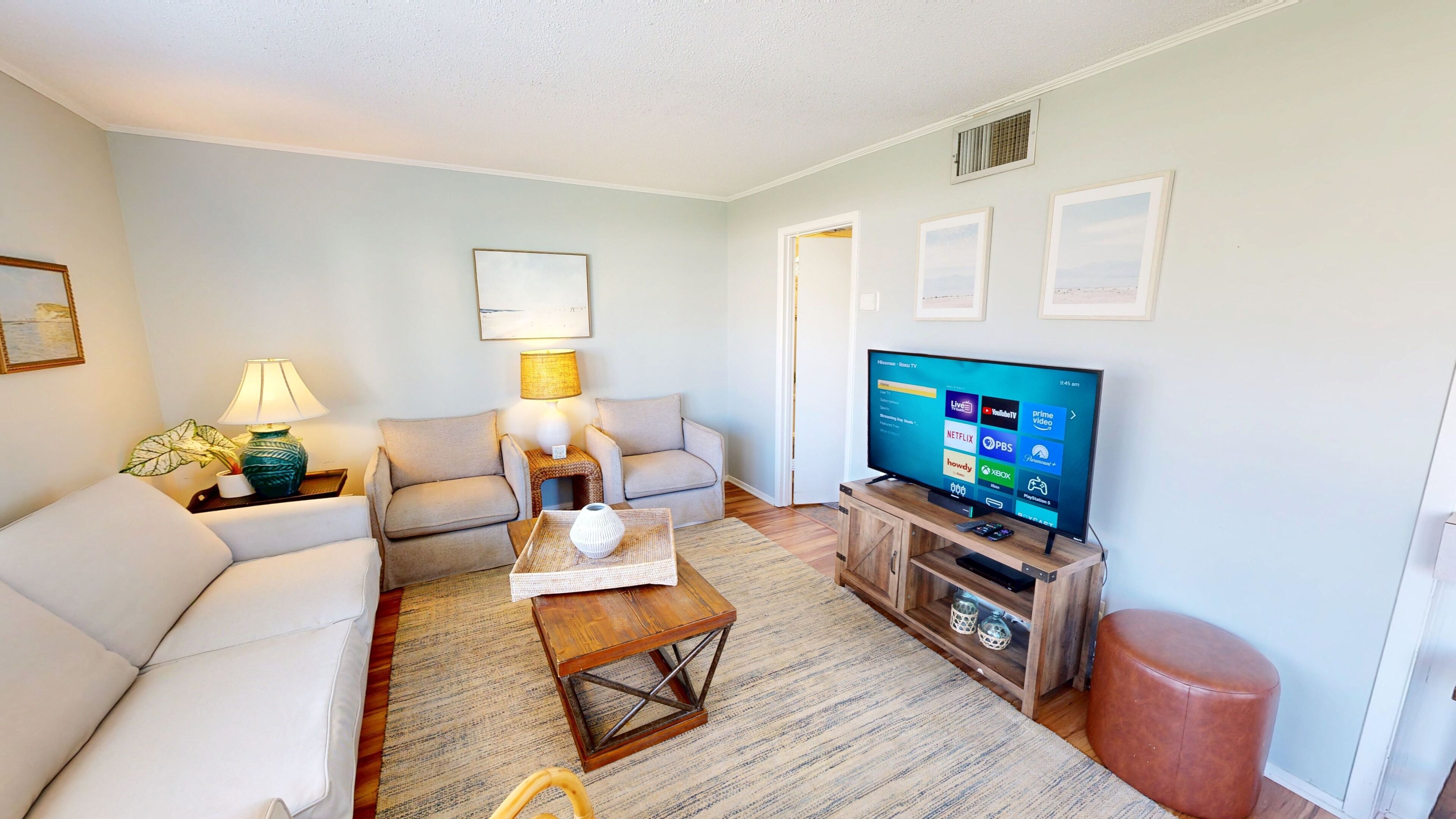 A living room with a sofa, a coffee table, a TV, and a lamp.
