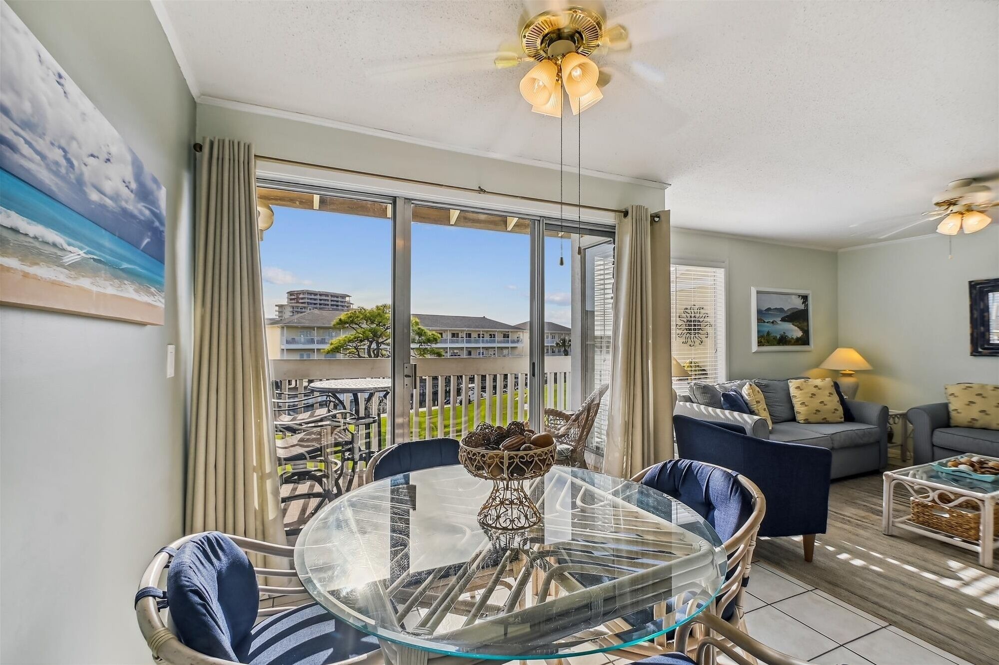 A spacious balcony with a glass table and chairs, a sofa, and a dining area.
