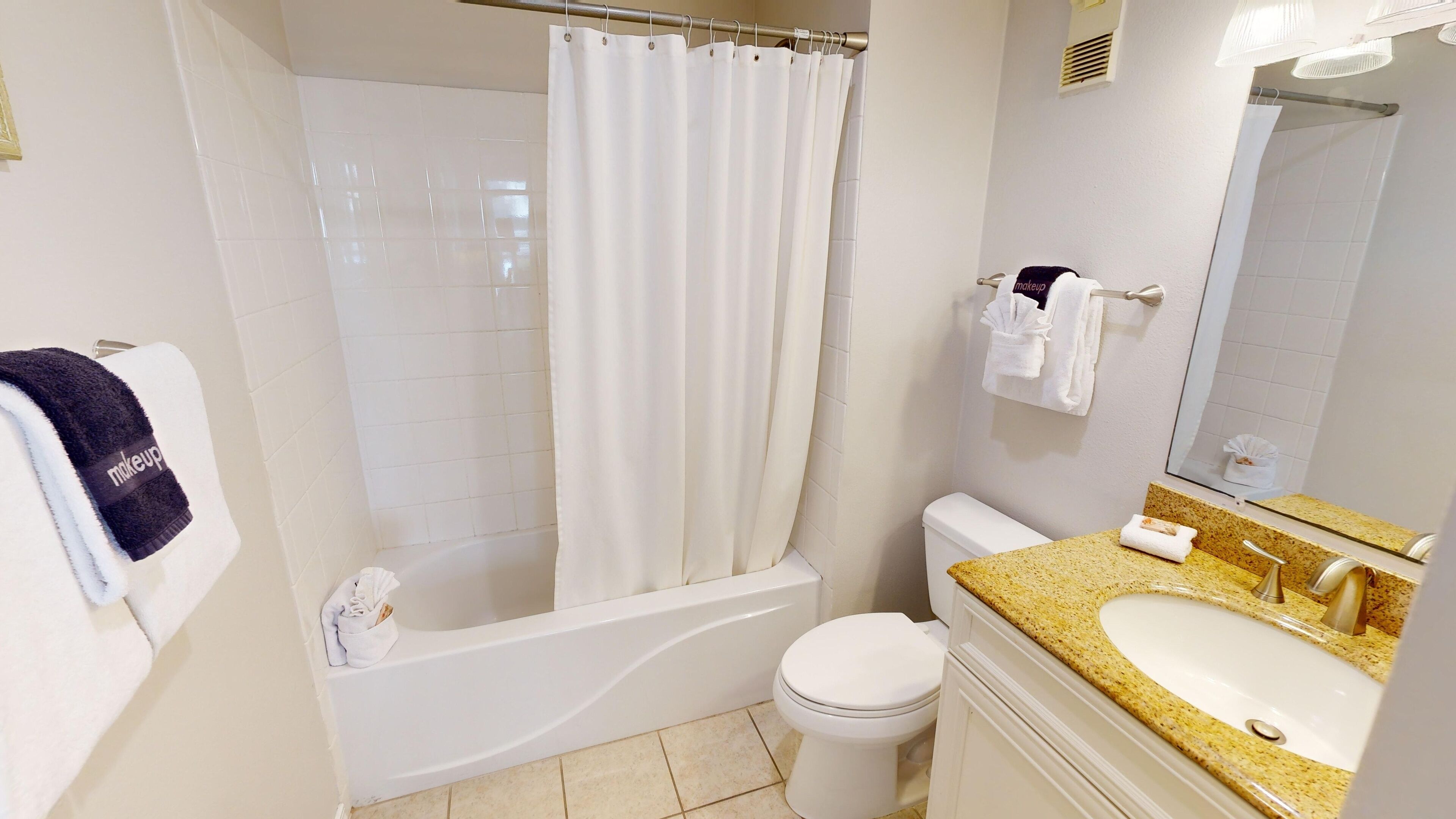 A modern bathroom with a bathtub, toilet, and sink.