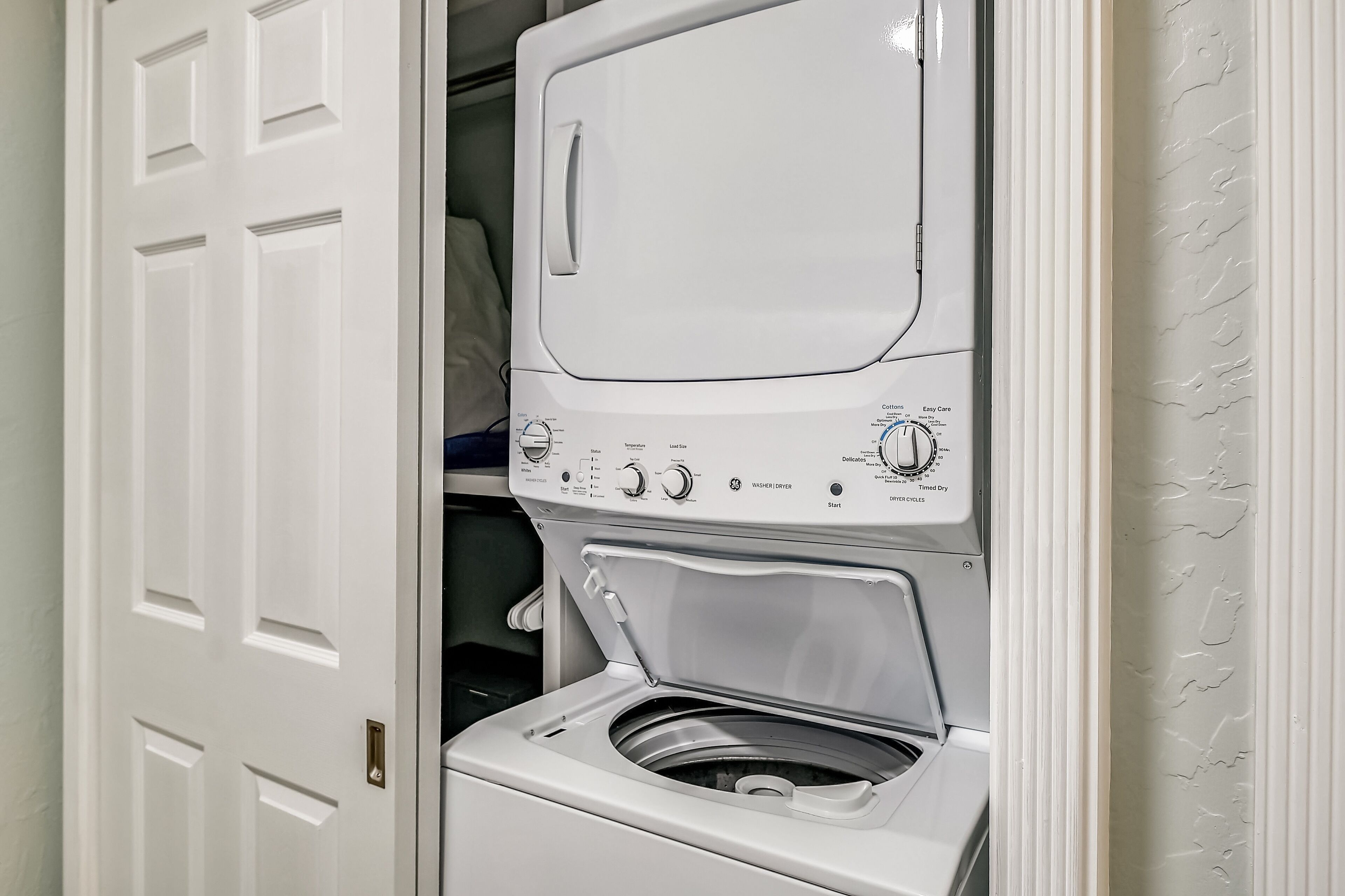 Un appareil combiné lave-linge et sèche-linge à chargement frontal, doté de boutons de commande et d’une porte.