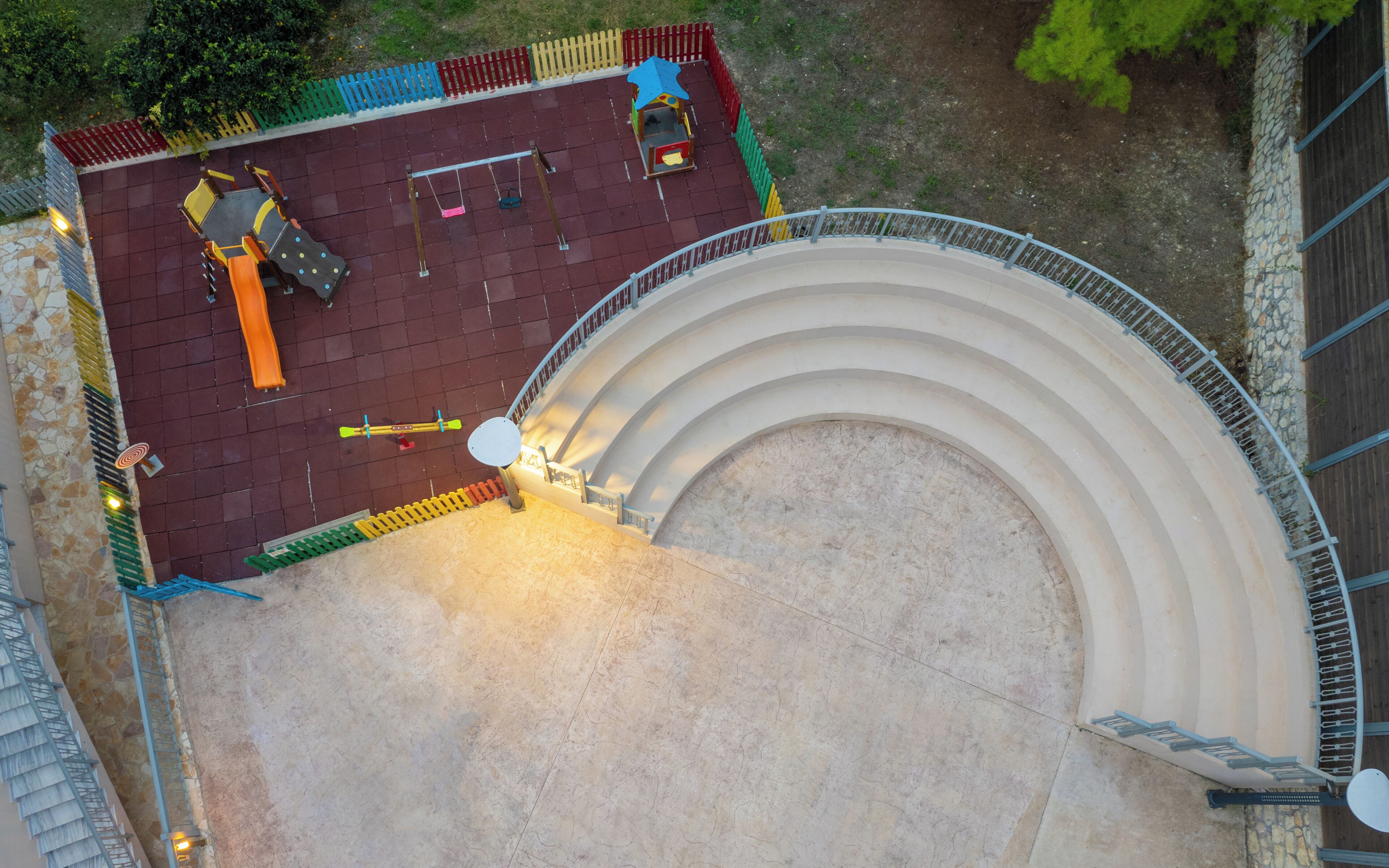 A circular outdoor area with a seating arrangement and a small play structure.