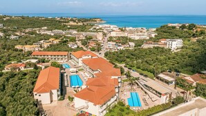 An aerial view of a resort with multiple buildings, swimming pools, and a coastline. - Karras Grande Resort (Zakynthos)