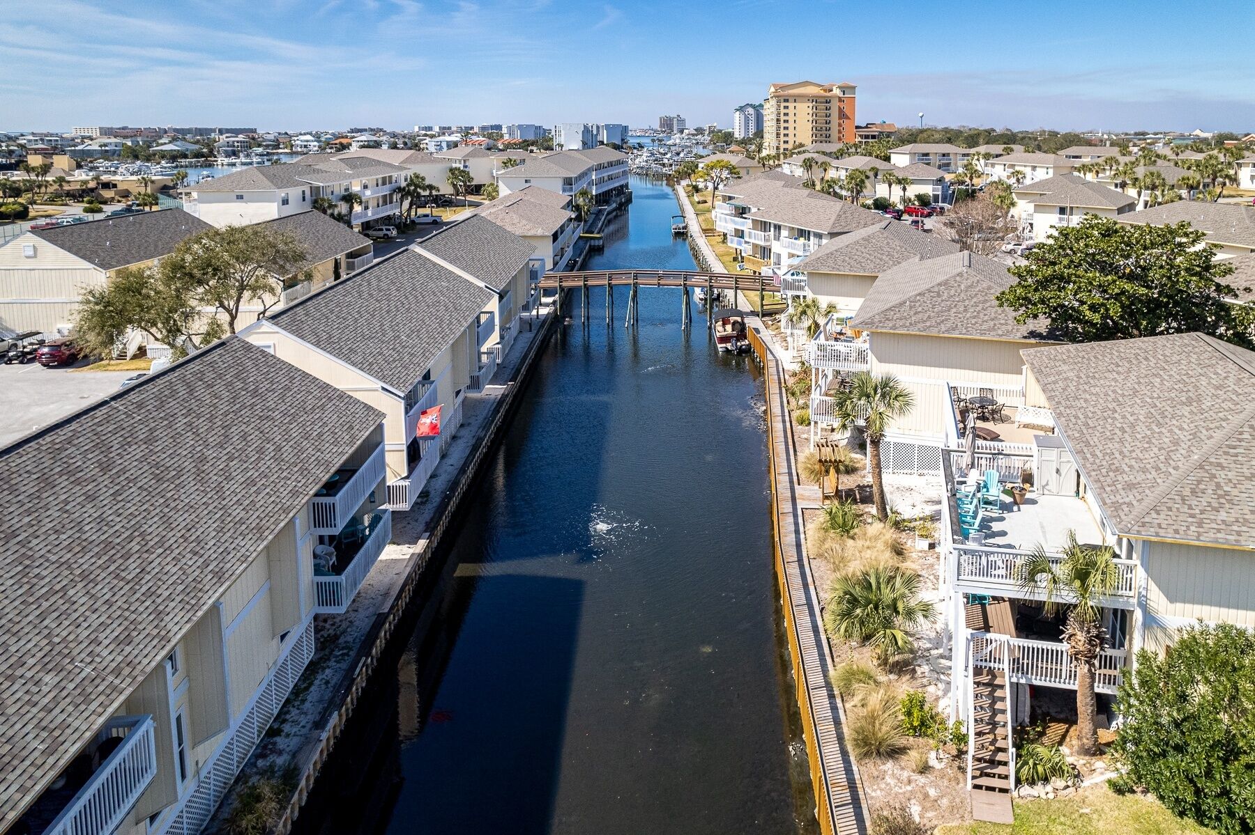 Un canal flanqueado por edificios, un puente y un paisaje urbano distante.