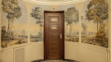 A wooden door with numbers 602 and 603, set in a hallway with a mural of trees and landscape.