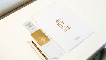 A white table with a booklet, a pen, and a small card.