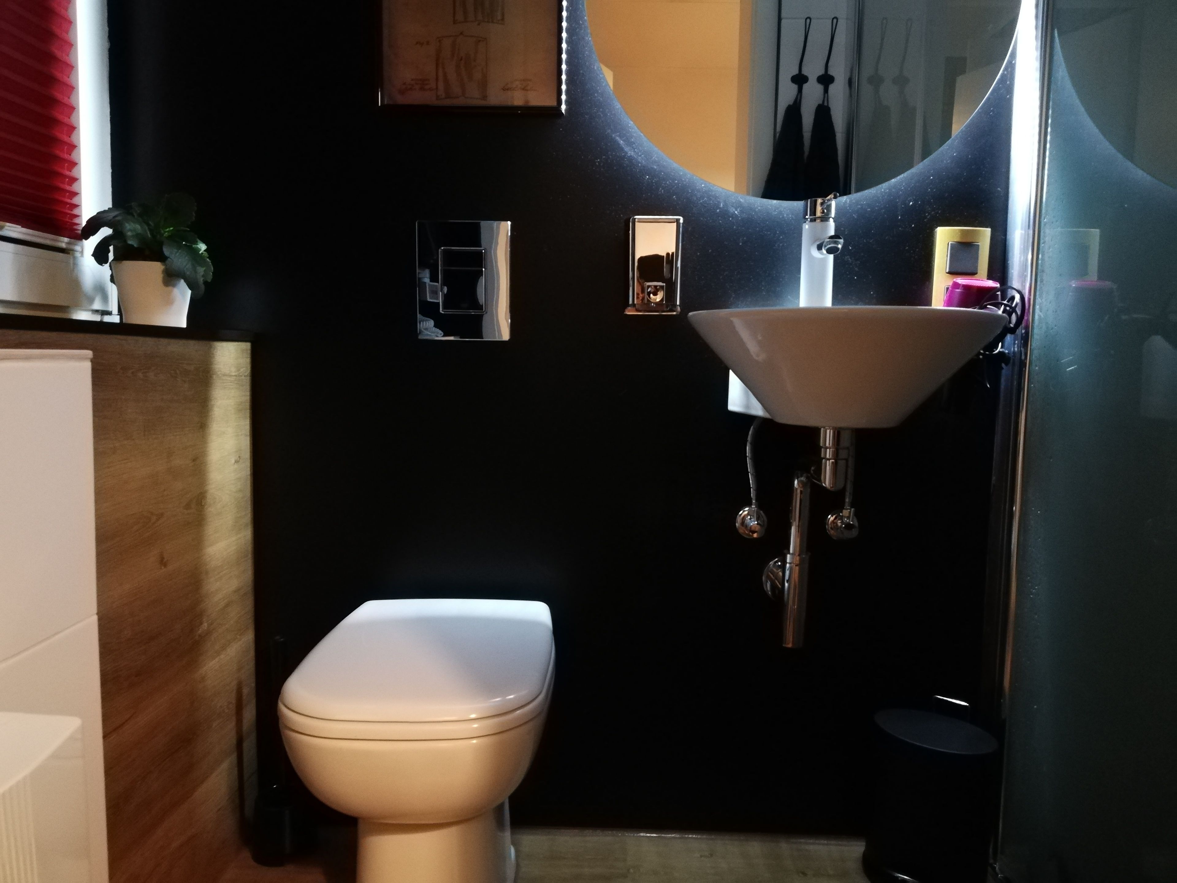 Ein kleines Badezimmer mit Toilette, Waschbecken und Spiegel.