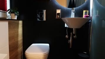 Ein kleines Badezimmer mit Toilette, Waschbecken und Spiegel.