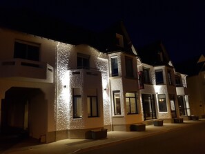 A hotel with a textured facade, multiple windows, and a sign indicating it is a hotel. - Les Chants d'Ailes - Hôtel Face Mer (La Turballe)