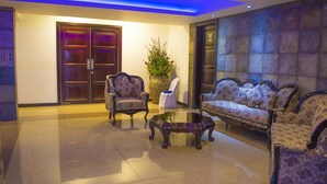 A lobby with a sofa set, two armchairs, a coffee table, and a large potted plant. - Hotel Payaqui (Esquipulas)