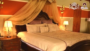 A bed with a canopy, bedside lamps, a wooden nightstand, and a wall with a logo. - Hotel Payaqui (Esquipulas)