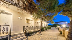 A two-story building with a stone-paved entrance and a staircase with metal railings. - Karras Livin (Zakynthos)