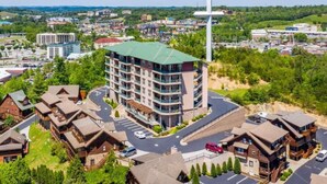 Ein mehrstöckiges Hotel mit Innenhof, umgeben von Wohnhäusern und einer markanten Kreuzkonstruktion.