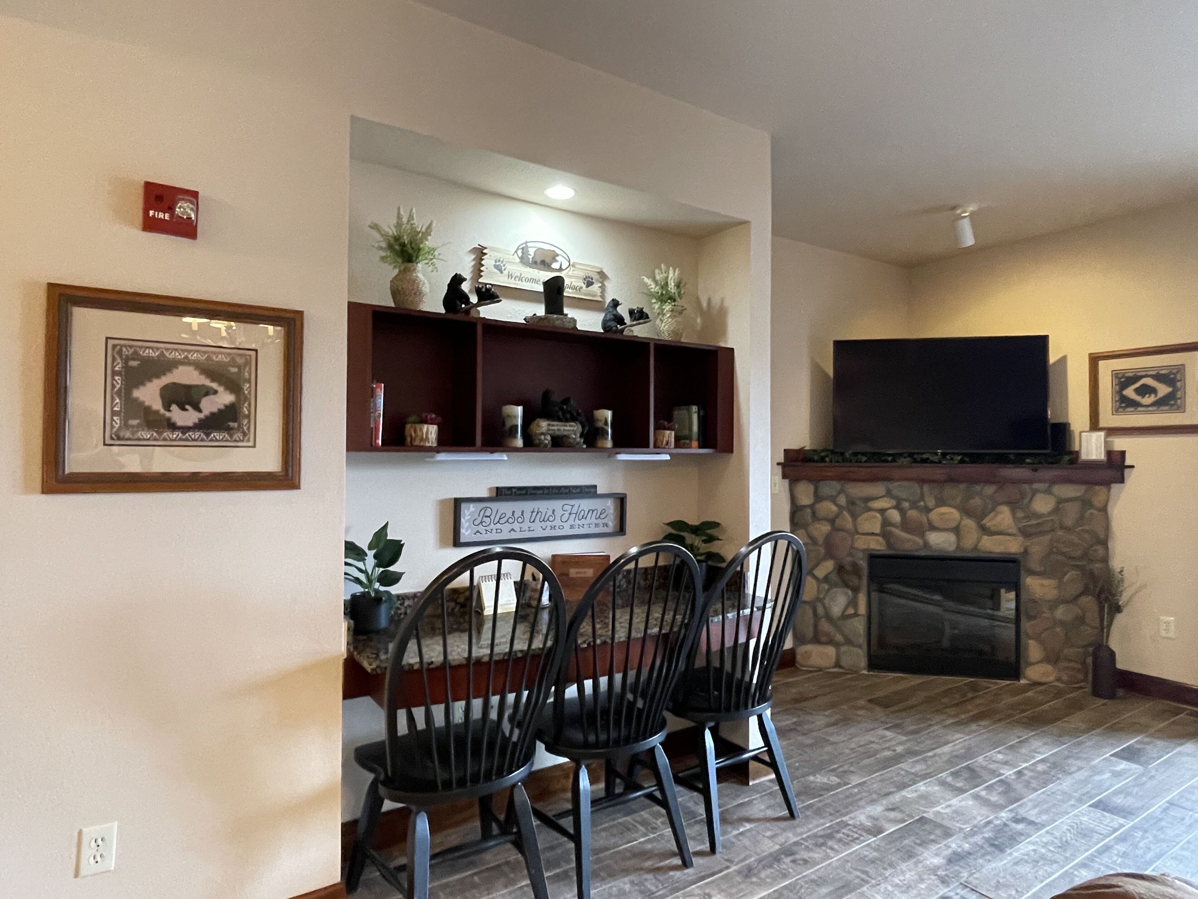 Una sala de estar con chimenea, televisor y comedor con sillas y mesa.