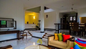 A spacious living area with a sofa set, a coffee table, and a dining area with chairs. - The Tamarind (Kandy)