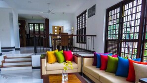 A spacious living area with a sofa set, a coffee table, and a dining area in the background. - The Tamarind (Kandy)