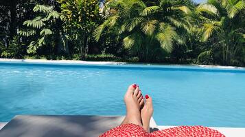 Una piscina al aire libre, sombrillas, tumbonas