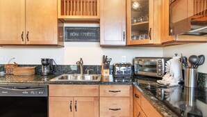 A kitchen with wooden cabinets, a coffee maker, a toaster, and a dishwasher.