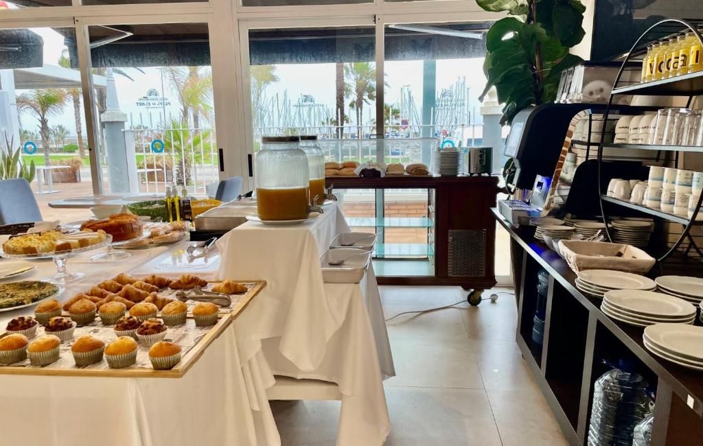 A breakfast buffet with various pastries, a coffee station, and a view of the outdoors.