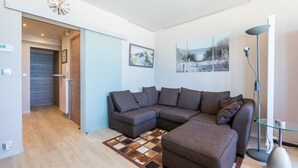A modern living room with a sectional sofa, a glass coffee table, and a floor lamp. - San Remo 501 (Koksijde)