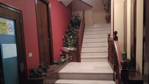 A staircase with wooden railings and a red wall. - Hospedaxe Don Manuel (O Vicedo)