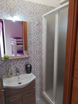 Familie vierpersoonskamer | Badkamer | Een douche, gratis toiletartikelen, een haardroger, een bidet