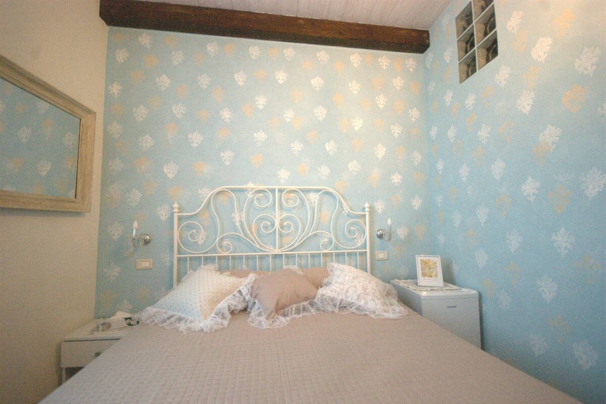 A bedroom with a bed, a nightstand, and a dresser.