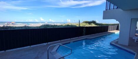 A swimming pool with a view of the beach and ocean.