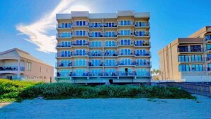 A multi-story hotel with balconies, a beach view, and a sandy foreground. - Florence I 608 Minium Studio Bedroom Condo by RedAwning (South Padre Island)