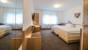 A hotel room with two beds, a desk, a chair, and a mirror. - Hotel am Wasen (Freiberg am Neckar)