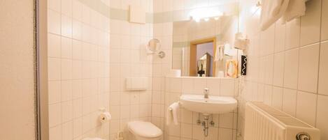 A bathroom with a bathtub, toilet, sink, and a mirror.