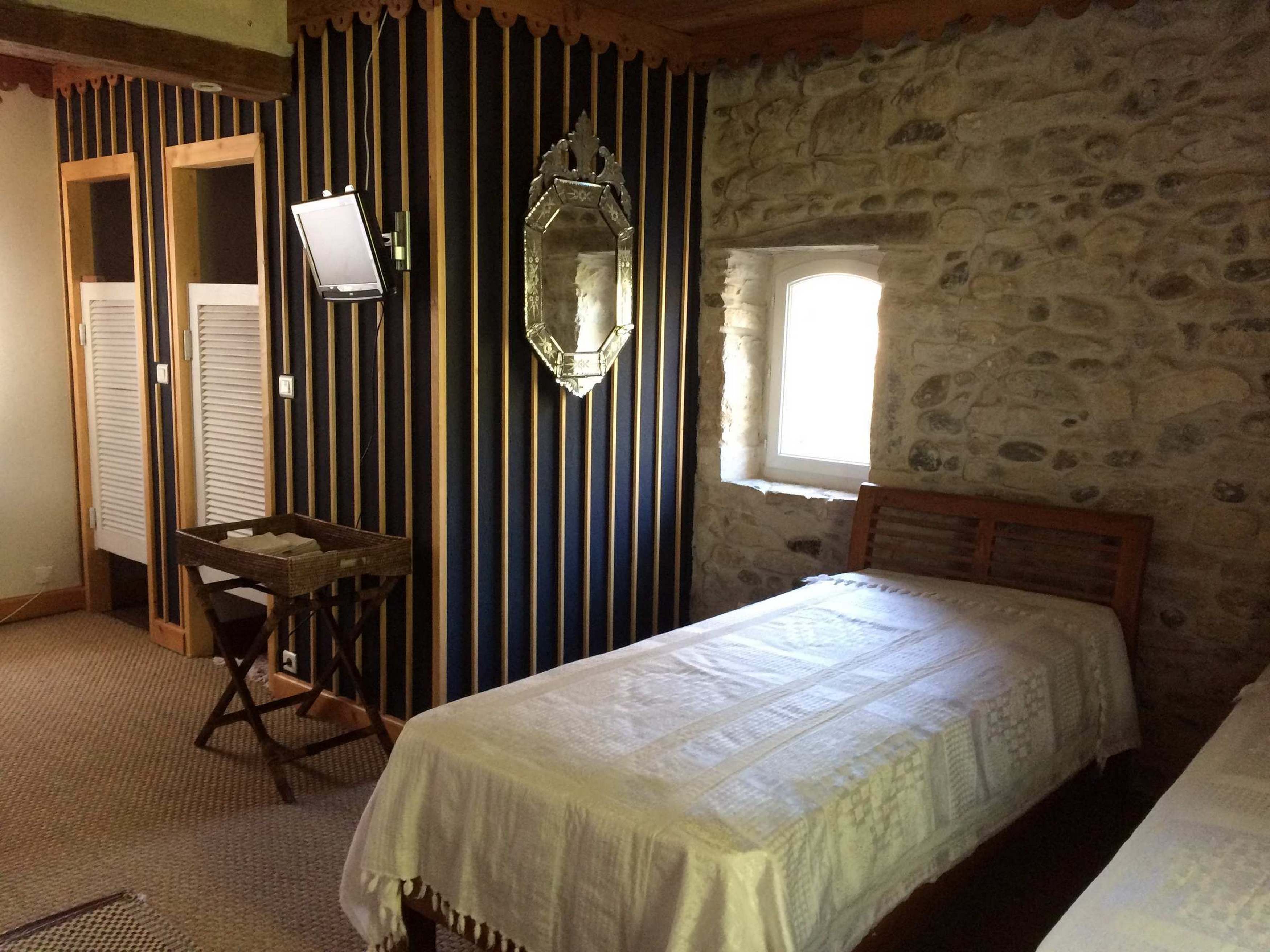 Ein Zimmer mit einem Bett, einem Schreibtisch, einem Spiegel und einem Fenster.