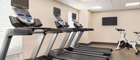 A gym with multiple treadmills, stationary bikes, and cardio equipment.