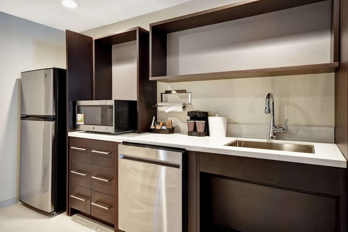 A modern kitchen with stainless steel appliances, a dishwasher, a microwave, and a sink with a faucet.
