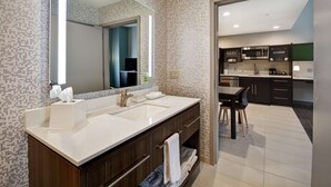 A modern bathroom with a double sink vanity, a large mirror, and a separate shower area. - Home2 Suites by Hilton Amherst Buffalo (Buffalo)