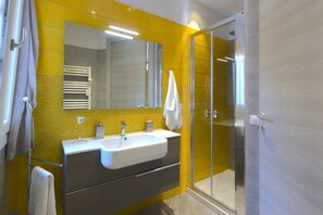 Habitación triple (Sole) | Baño | Regadera, amenidades de baño gratuitas, secadora de cabello, batas 