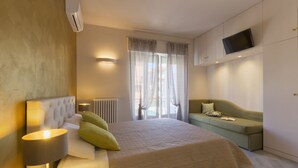 A modern hotel room with a large bed, a sofa, a flat-screen TV, and a window with curtains. - B&B Da Peo (Porto San Giorgio)