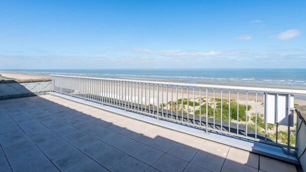 A balcony with a metal railing overlooking a beach and ocean. - Magellan 701 (Koksijde)