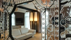 A room with a large ornate mirror reflecting a living area with a sofa and a television. - Penthouse Suite Rome (Rome)