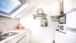 Eine Küche mit Dachfenster, einer Uhr und einer Mikrowelle.