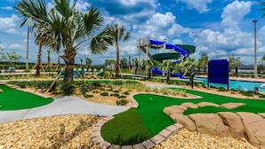 Een waterpark met een zwembad, glijbanen en een minigolfbaan.