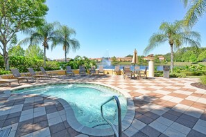 A pool area with lounge chairs and a view of a body of water. - 2651en (Kissimmee)