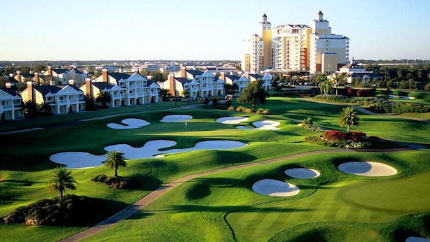 A golf course with bunkers and a hotel in the background. - 2076r (Kissimmee)