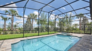 A swimming pool with a clear blue water, surrounded by a metal fence and palm trees. - Solara 9 Bedroom House w Pool - 8100SA (Kissimmee)