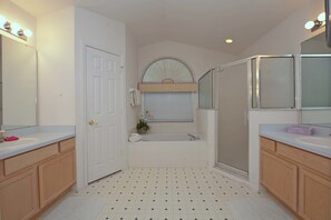 A bathroom with a white sink, a bathtub, and a shower.