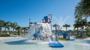 Un parque acuático con tobogán de agua, palmeras y cielo azul brillante.