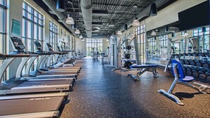 Un gimnasio con cintas de correr, máquinas de pesas y mancuernas.