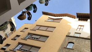 Un edificio de varios pisos con fachada amarilla, múltiples ventanas y balcones.