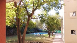 A backyard with a swimming pool, trees, and a stone pathway. - Convivir Departamentos (Córdoba)