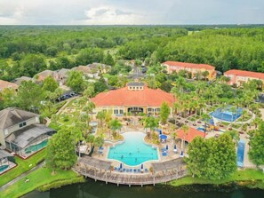 A resort with a central swimming pool, multiple guest villas, and a surrounding natural landscape. - Terra Verde 705 (Kissimmee)