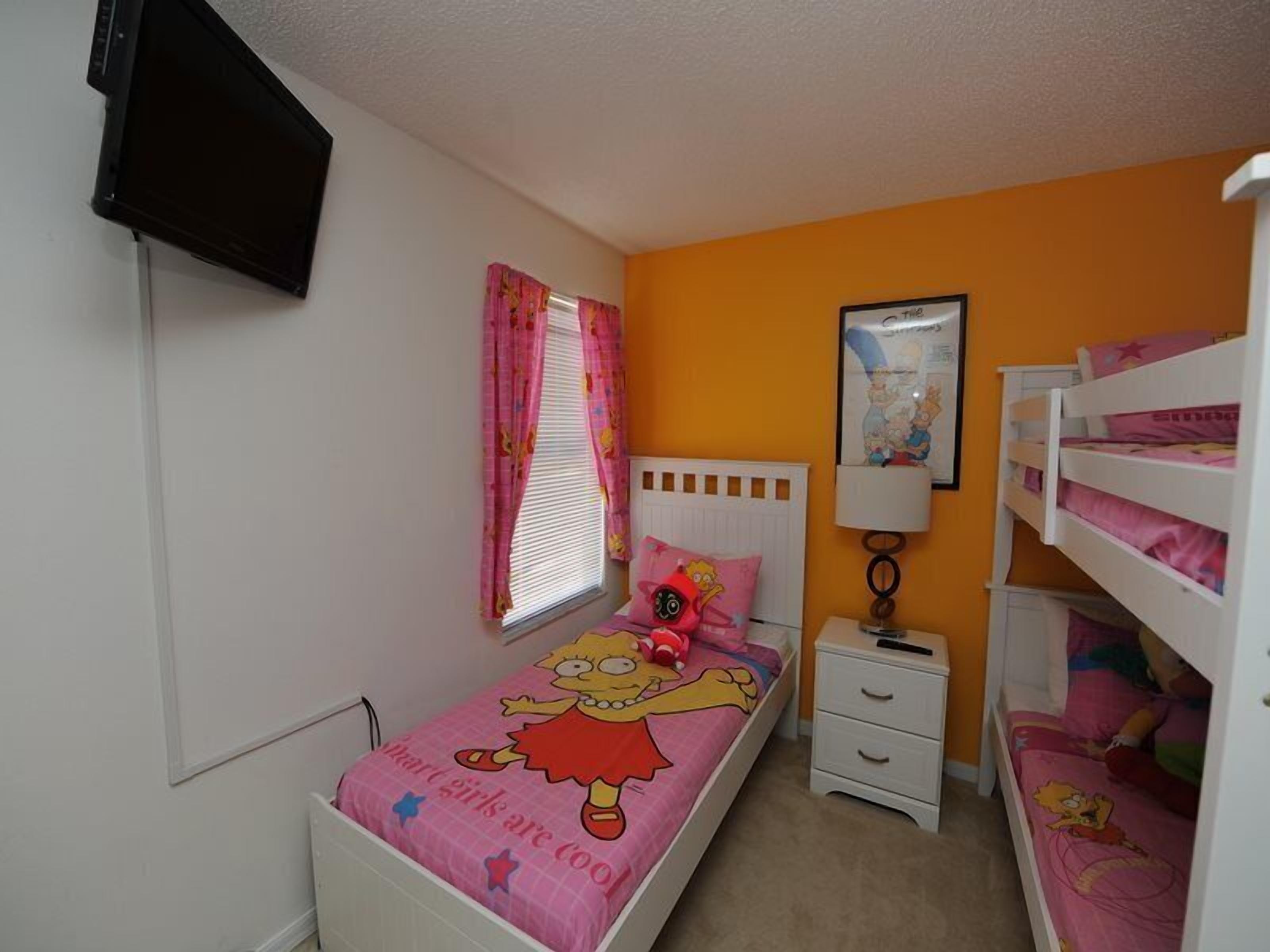 A child's bedroom with a single bed, a nightstand, a TV mounted on the wall, and a bunk bed with children's bedding.